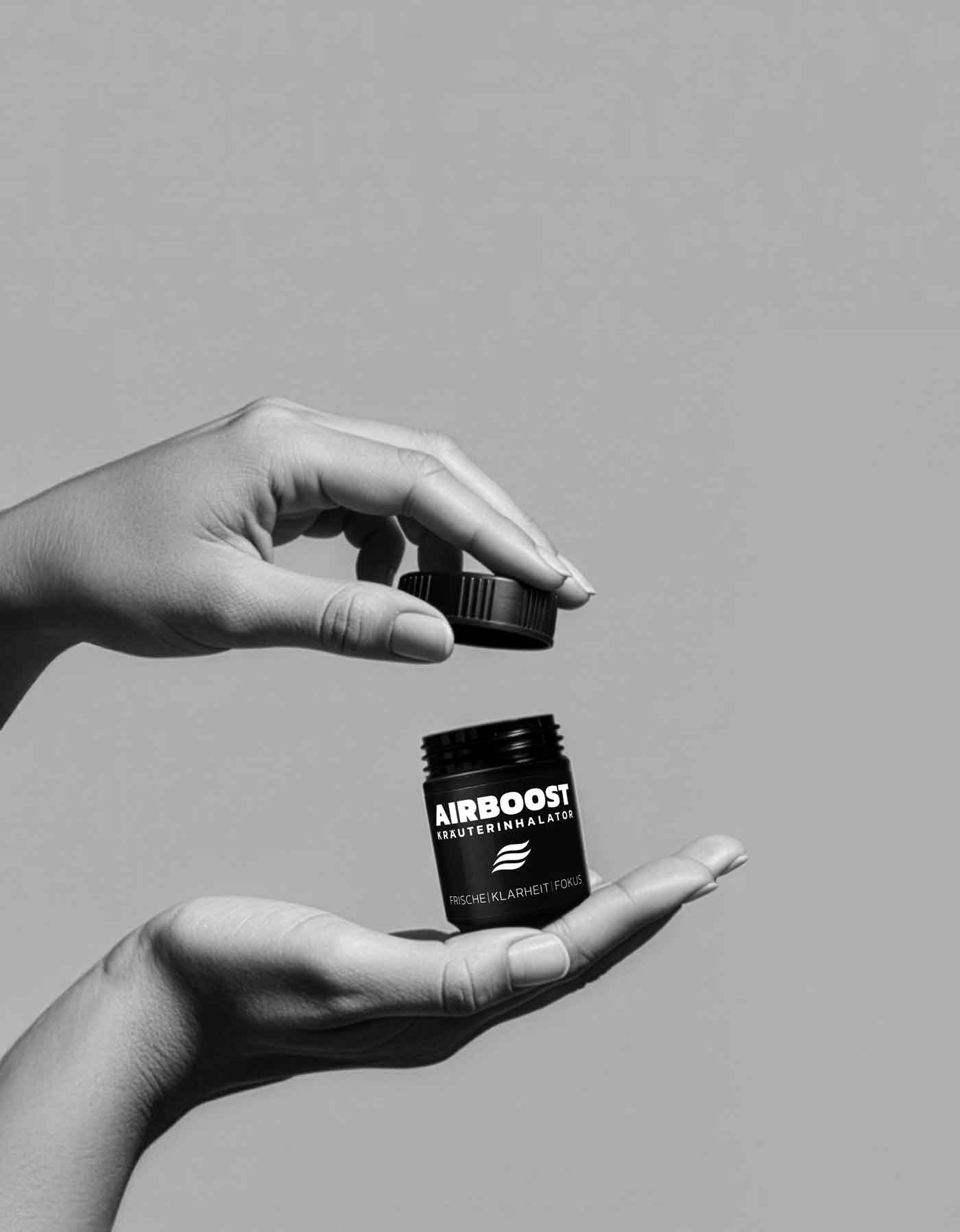 AIRBOOST Kräuterinhalator Anwendungsbild - Hand öffnet die Dose mit Drehverschluss während die andere Hand die Dose hält