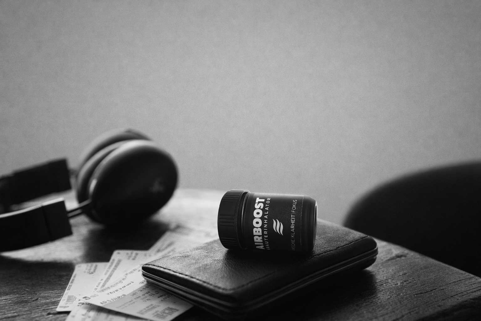 AIRBOOST Kräuterinhalator im Alltag auf einer Geldbörse auf grauem Hintergrund - perfekt zum Reisen und für Business Reisen für sofort freien Atem